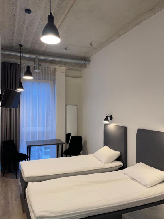 two beds in a room with a table and chairs at Apartment Loftas13-6 in Kretinga