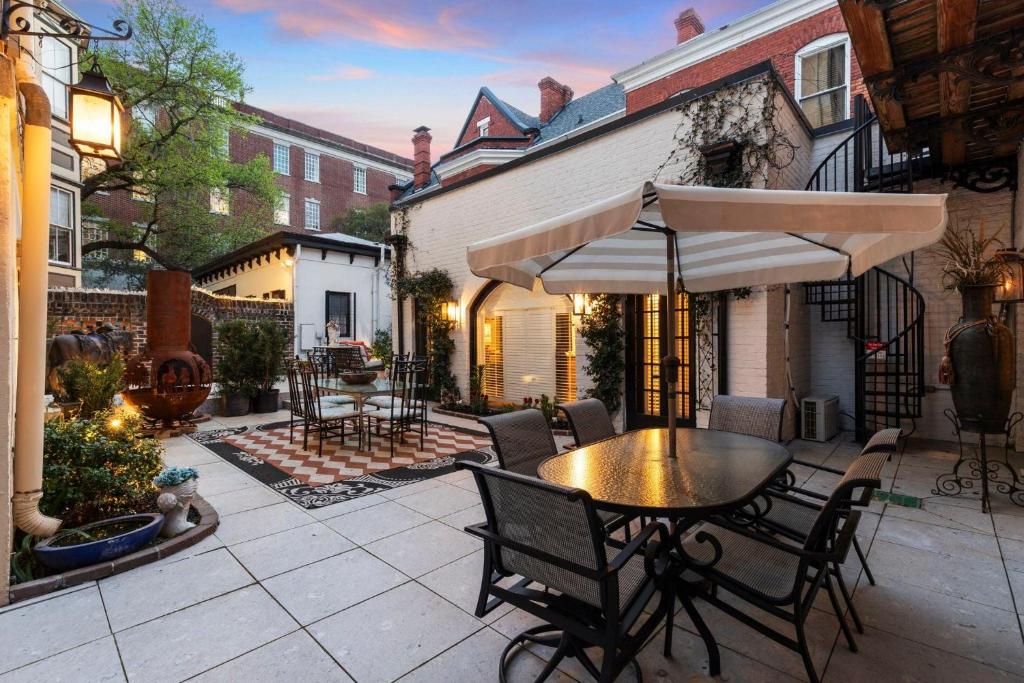 a patio with a table and chairs and an umbrella at The Stables in Savannah
