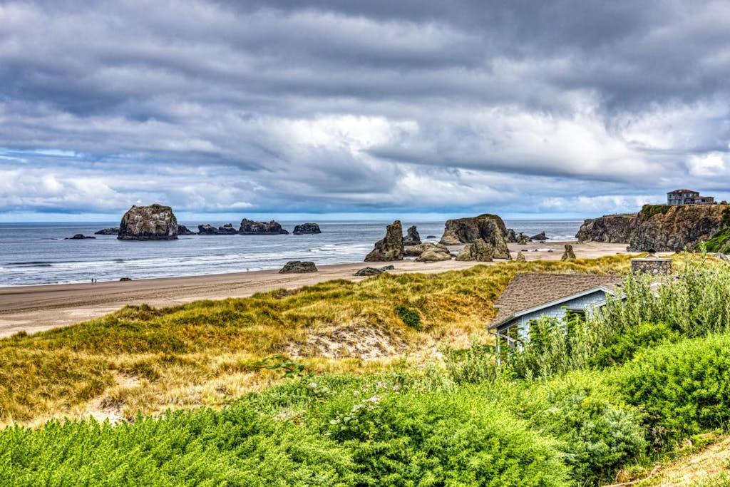 a house on a beach with rocks in the ocean at Inviting dog-friendly studio with unobstructed ocean views in Bandon