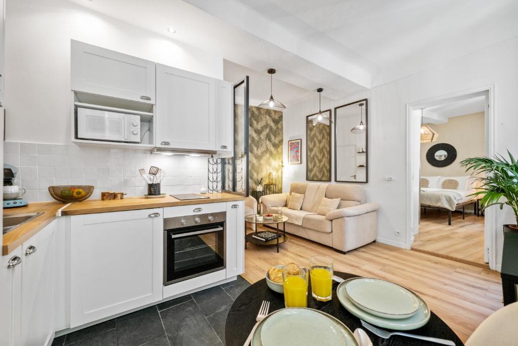 a kitchen with white cabinets and a living room at Sky Lodge - Vieux Nice in Nice