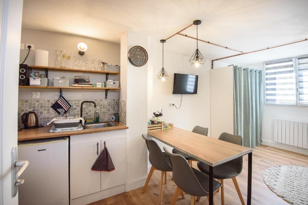 a kitchen and dining room with a table and chairs at Studio tout confort proche des thermes in Vals-les-Bains