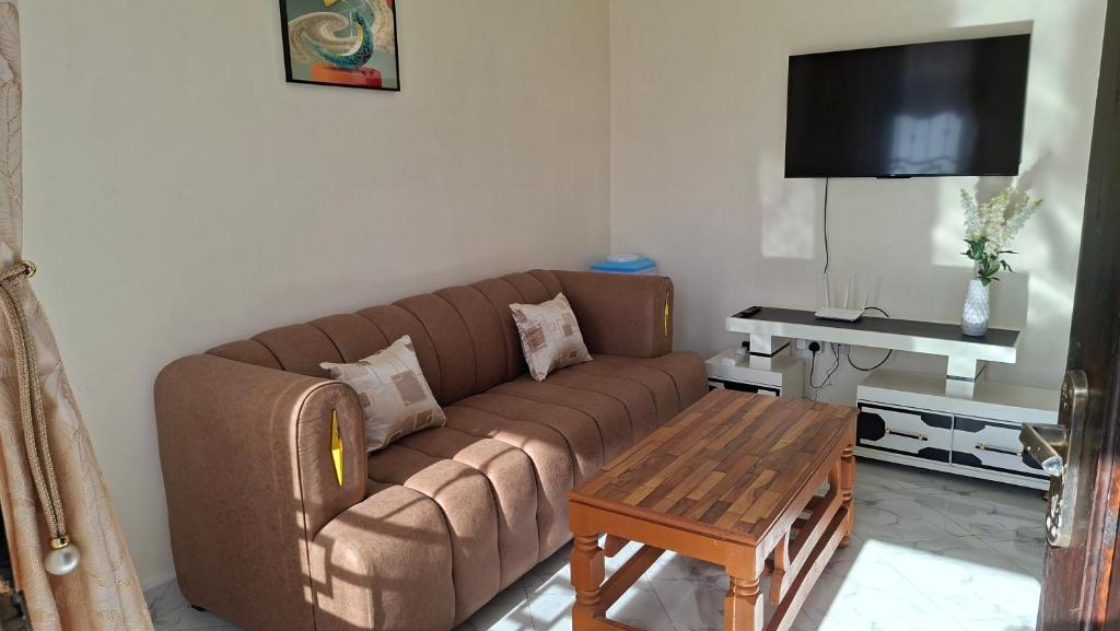 a living room with a brown couch and a table at Westwood Homes in Kilifi