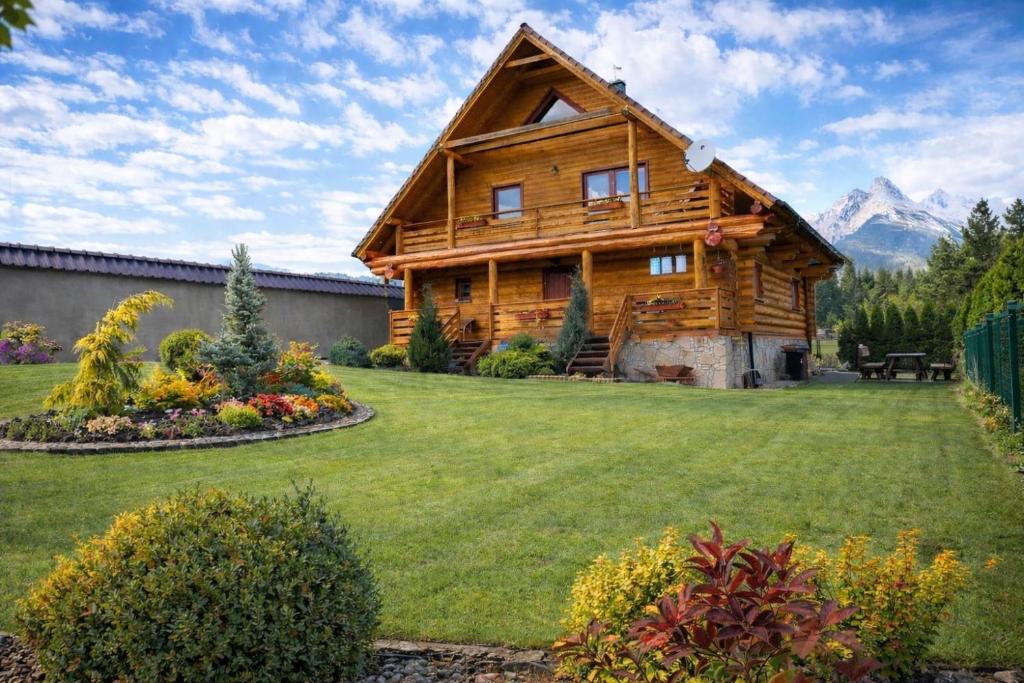 a log cabin in the mountains with a yard at Wellness Chalet Tatry in Vysoké Tatry