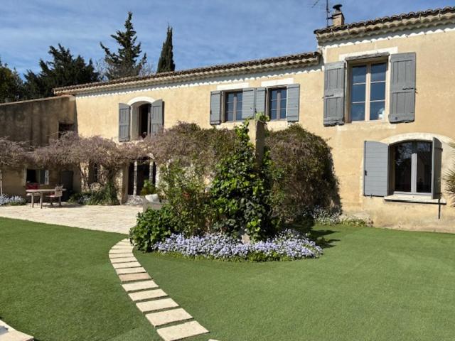 una casa con un cortile verde con fiori davanti di BROSSARD a Cavaillon