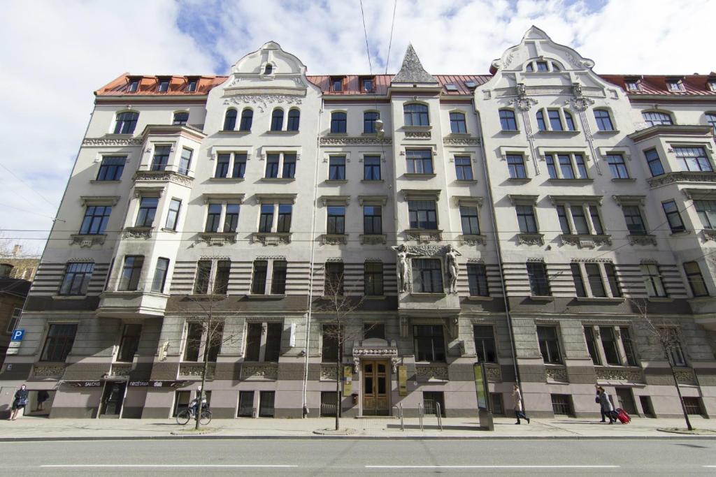 duży biały budynek na rogu ulicy w obiekcie Valdemara Residence Hostel w Rydze