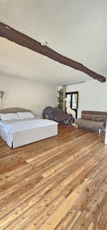 a bedroom with a bed and a wooden floor at Villa Rosetta in Airasca
