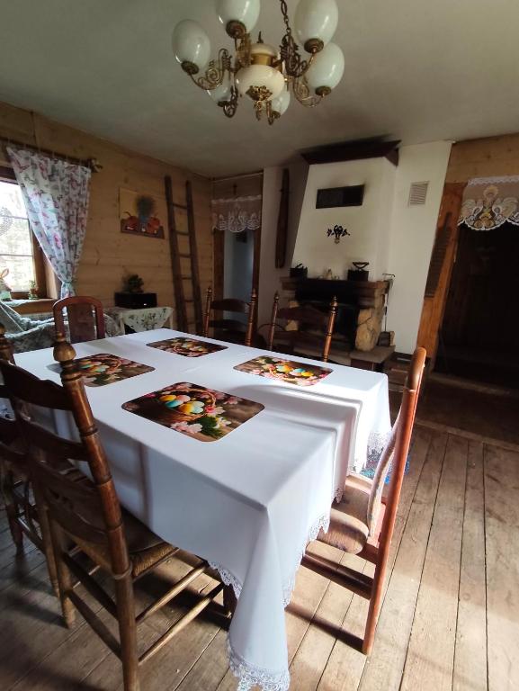 a dining room table with a white table cloth on it at Agroturystyka LipoweWzgórze domek Danusia in Tereszpol