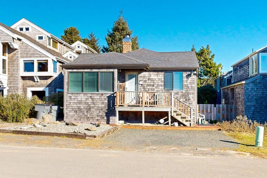 a brick house with a porch and a balcony at Charming oceanfront cottage with WiFi & easy beach access in Cannon Beach