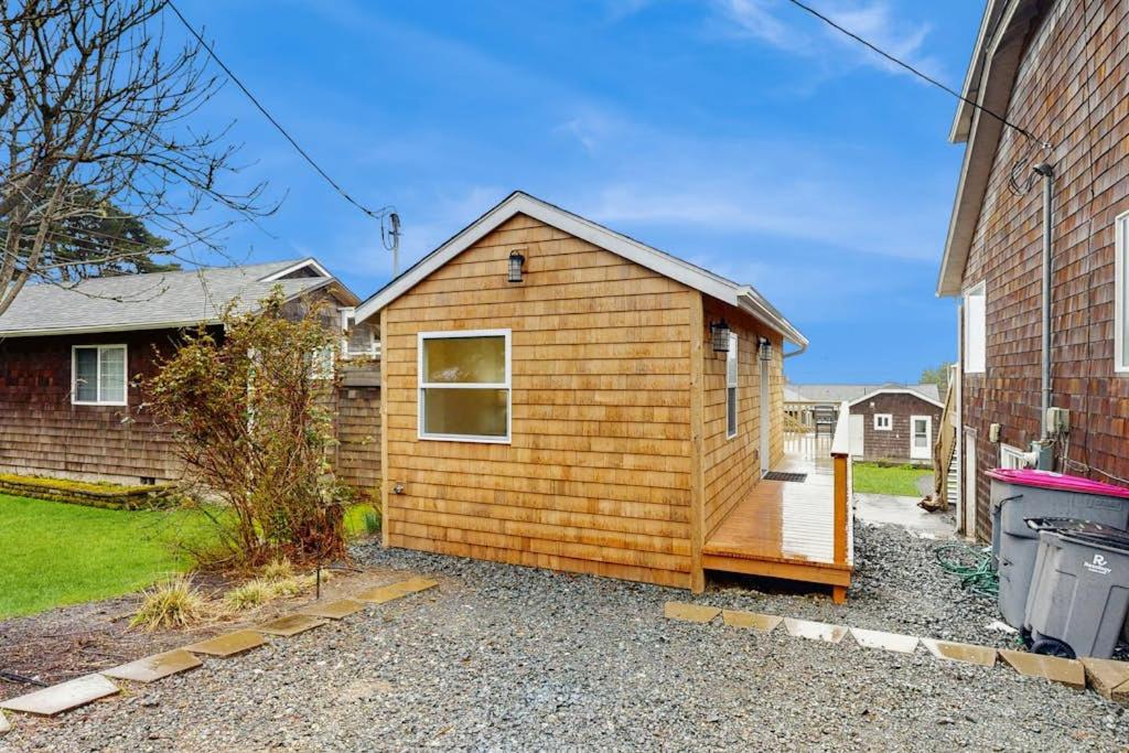 a wooden cabin in a yard next to a house at Dog-friendly comfy cabin only two blocks from the beach in Cannon Beach