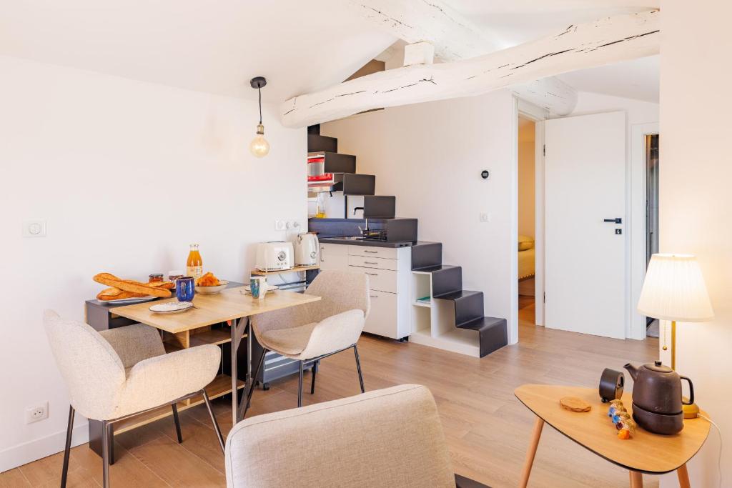 a kitchen with a table and chairs and a staircase at Apt Le Frene in Tourrettes-sur-Loup