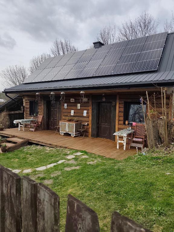 a log cabin with solar panels on the roof at Agroturystyka LipoweWzgórze- Jaś&Małgosia in Tereszpol