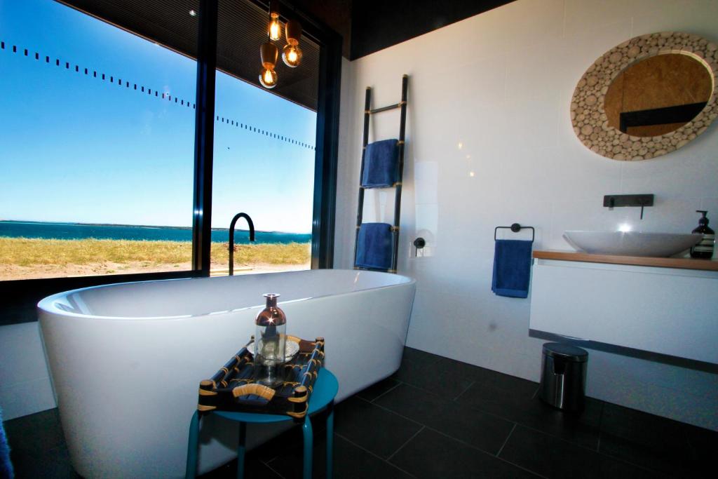 
a bath room with a tub and a chair at Perlubie Sea in Perlubie
