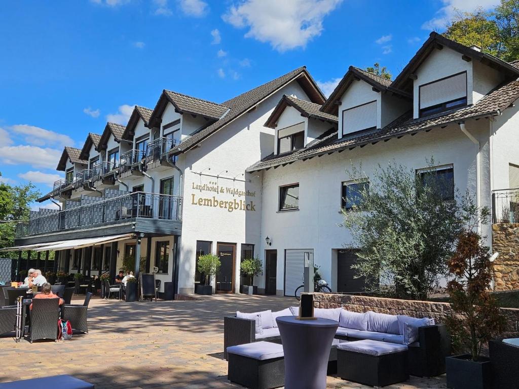 a large white building with couches in a courtyard at Landhotel Lembergblick in Feilbingert