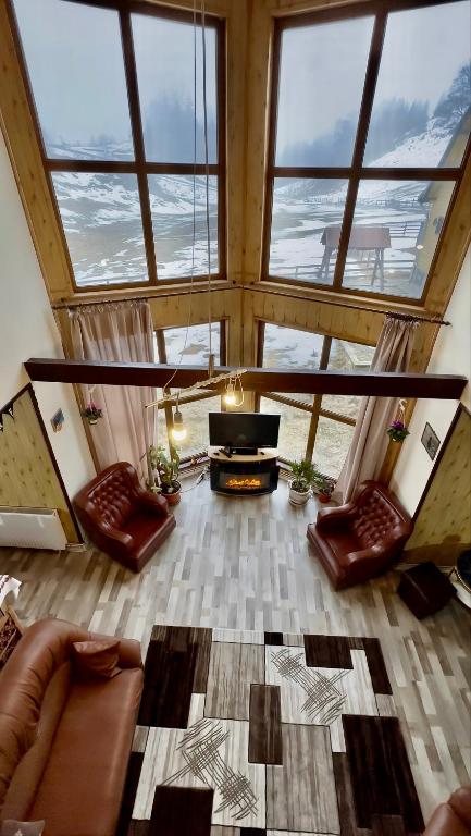 a living room with a couch and a piano at Plaiul Carpatin in Fundăţica