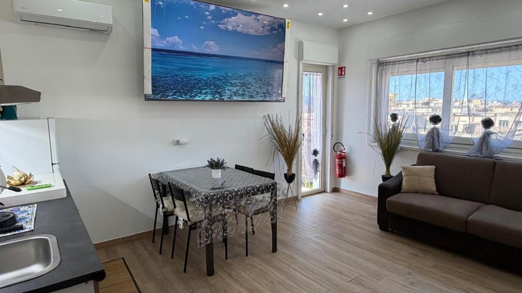 a kitchen and living room with a table and a couch at Un Tuffo nello Stretto in Villa San Giovanni