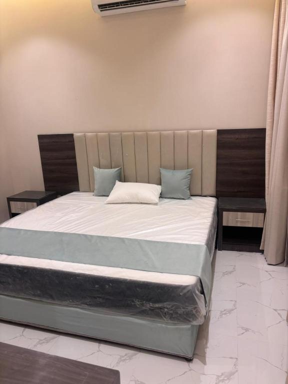a bedroom with a large bed with blue pillows at استديو تراحيب لبن للضيافة in Riyadh