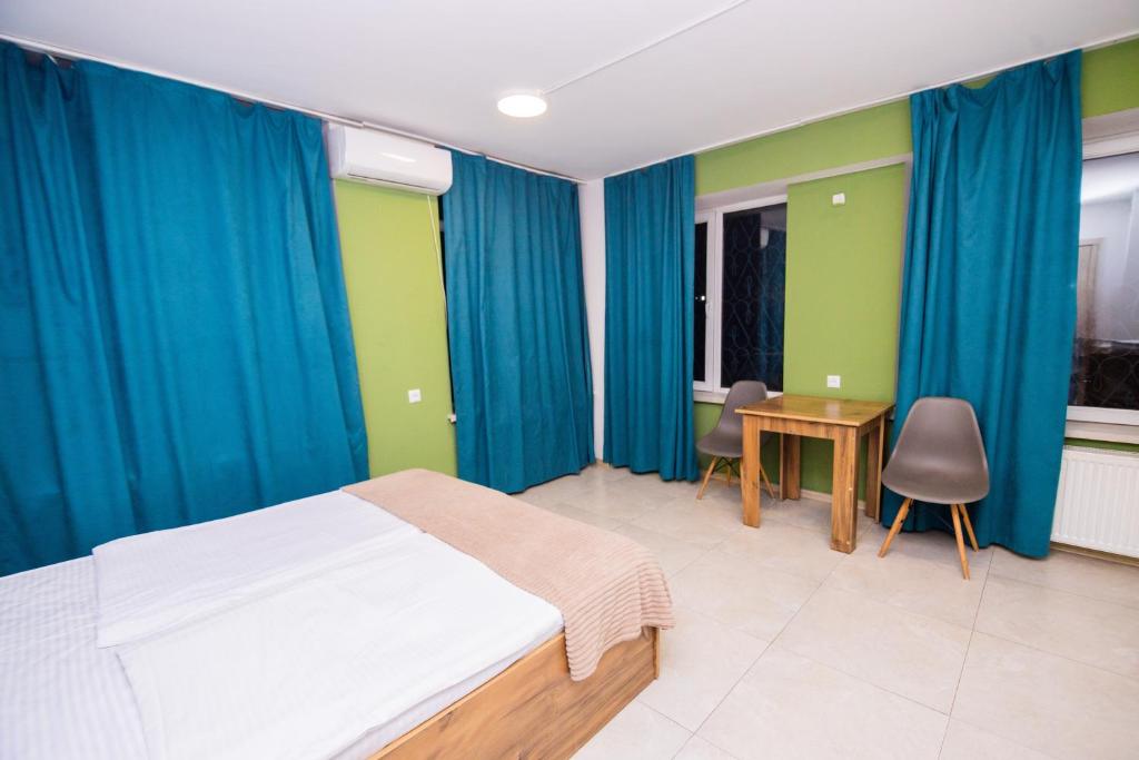 a bedroom with blue curtains and a bed and a desk at The Best Hostel in Yerevan