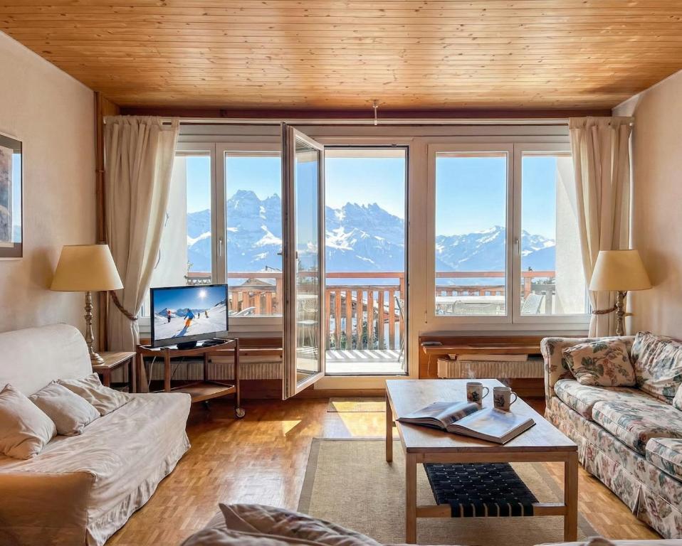 a living room with a view of a mountain at Villars - Charme et panorama in Ollon