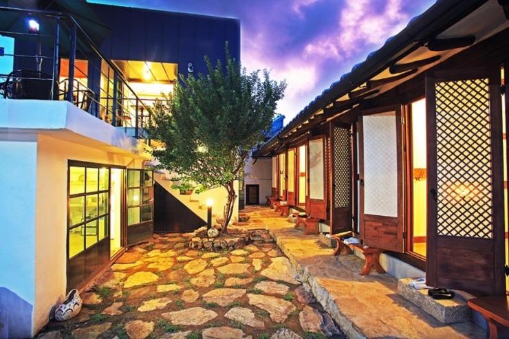 a courtyard with a tree in the middle of a building at Dowon Guesthouse in Jeonju