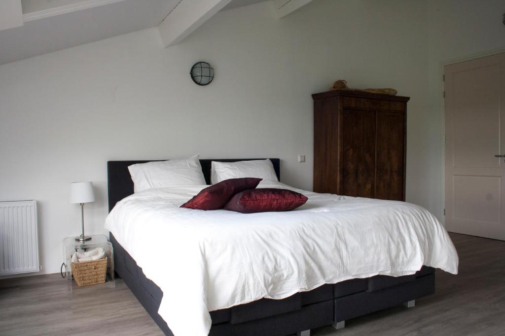 a bedroom with a large bed with two pillows on it at Klein-Amerika in Groesbeek