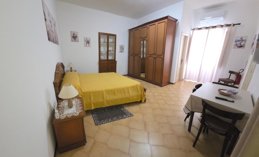 a bedroom with a yellow bed and a table at Conchiglia in Lipari