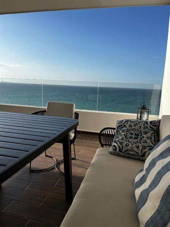 a balcony with a table and a bench and the ocean at Chicxulub , oceanfront 3 recamaras in Chicxulub