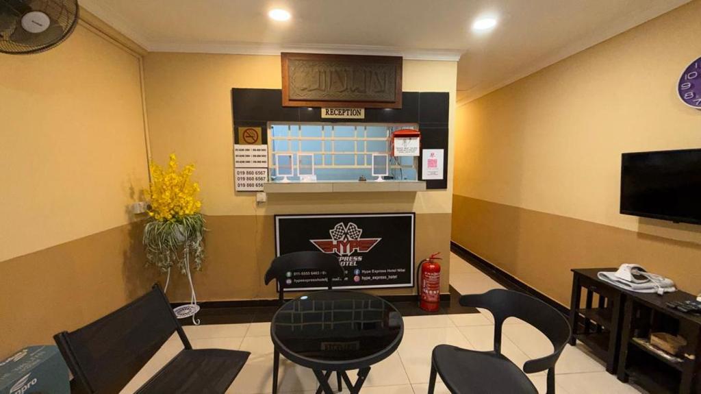 a living room with a table and chairs and a tv at Jam Hotel Nilai in Nilai