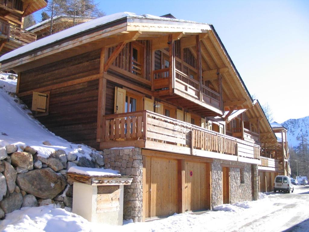 イゾラ 2000にあるSCI Chalet Dempureの雪の中にバルコニーが付いた大きな木造の家