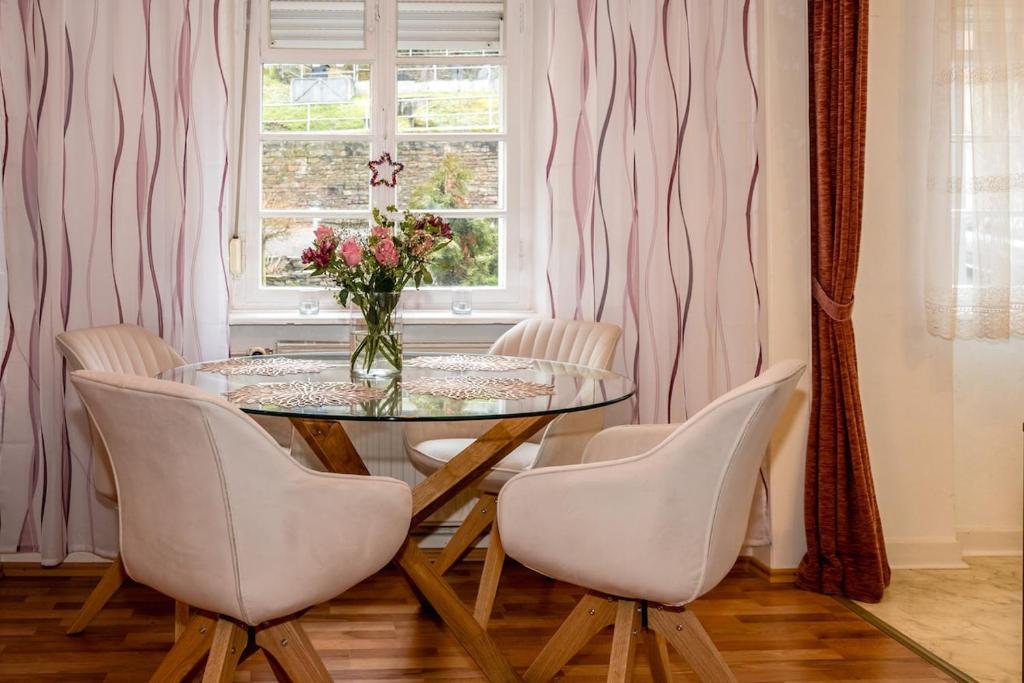 a dining room with a glass table and chairs at Frankfurter Haus in Zell an der Mosel