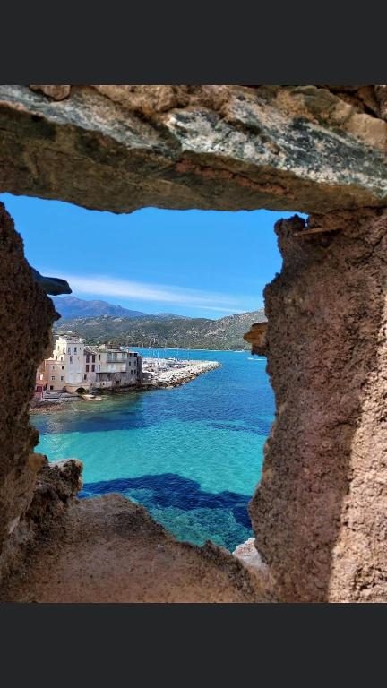 a view of the ocean from a rock window at Duplex face à la mer in Saint-Florent