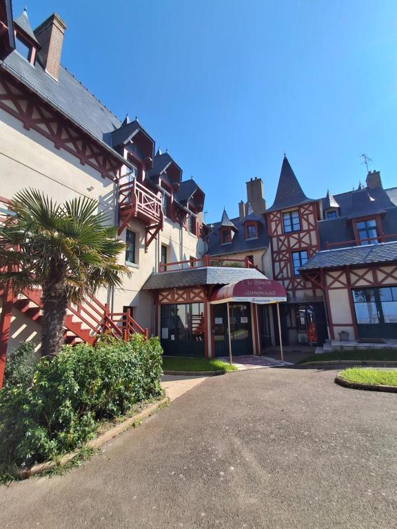 a large building with a palm tree in front of it at Manoir Du Cunningham in Saint Malo