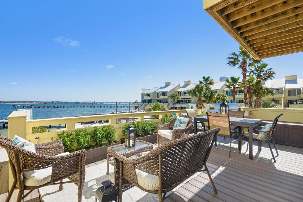 a patio with tables and chairs on a deck at Buena Vida 22 - A in Navarre