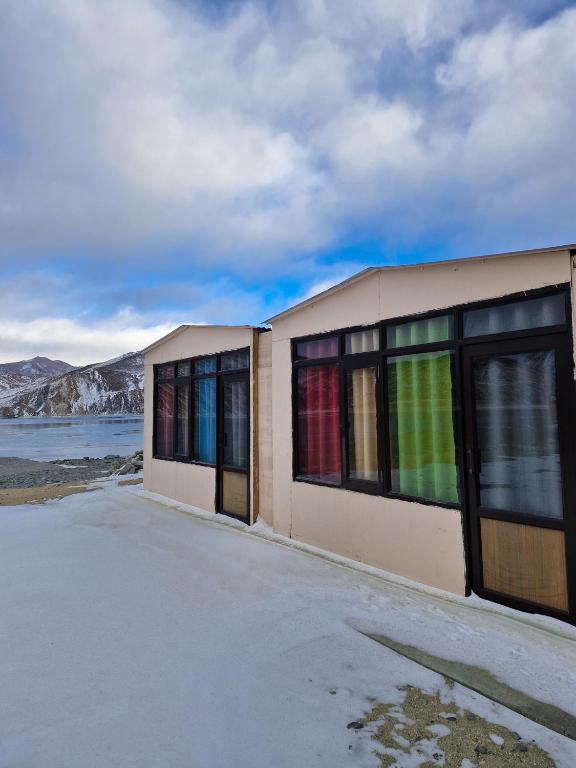 a building with colorful windows on the side of it at pangong rainbow cottage in Lukung