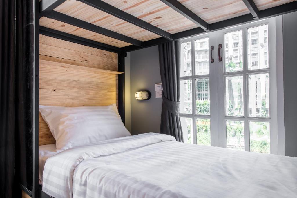 a bedroom with a bed and a large window at X9Hostel in Bangkok