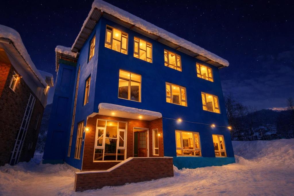 a blue house in the snow at night at THE NUN KUN Pahalgam in Pahalgām