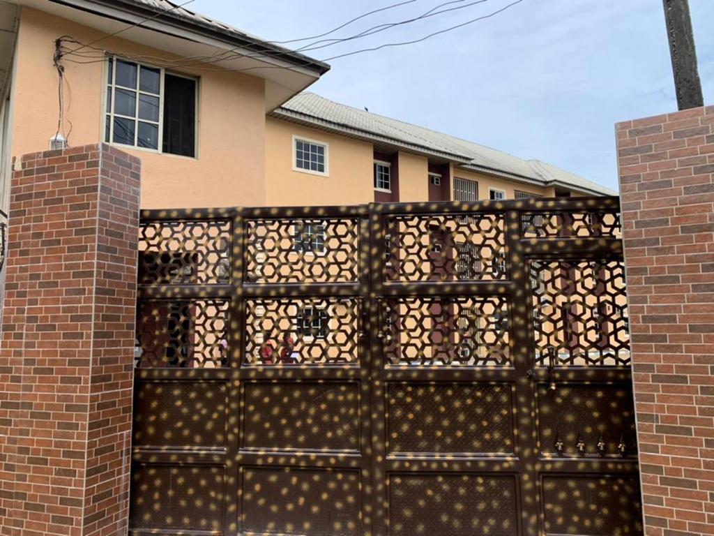 a fence with an iron gate in front of a house at Classic Hills Hotel & Resort in Uyo