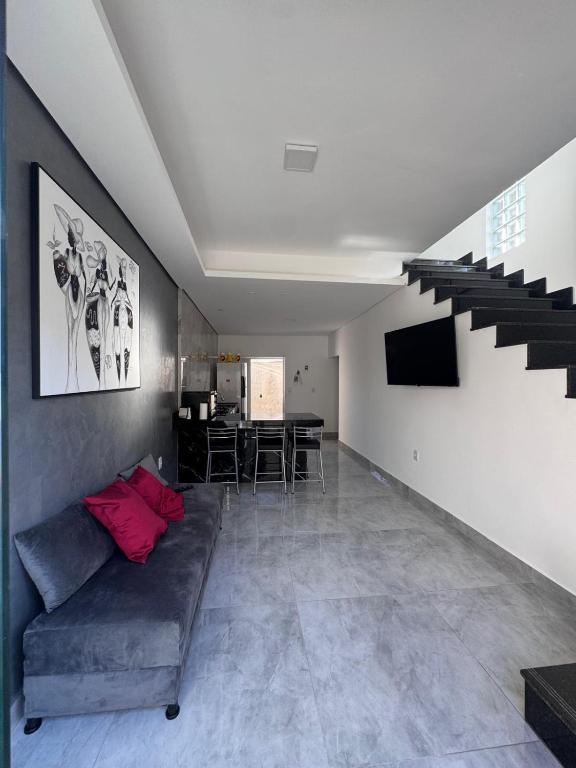 a living room with a couch and a staircase at Casa Hospedagem e Temporada Mobiliada in Sete Lagoas