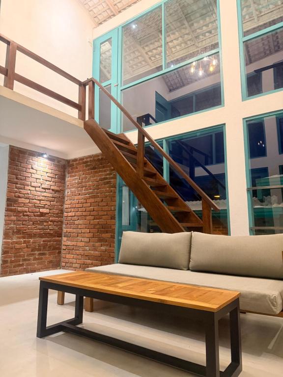 a living room with a couch and a staircase at casa luna villa in Narigama