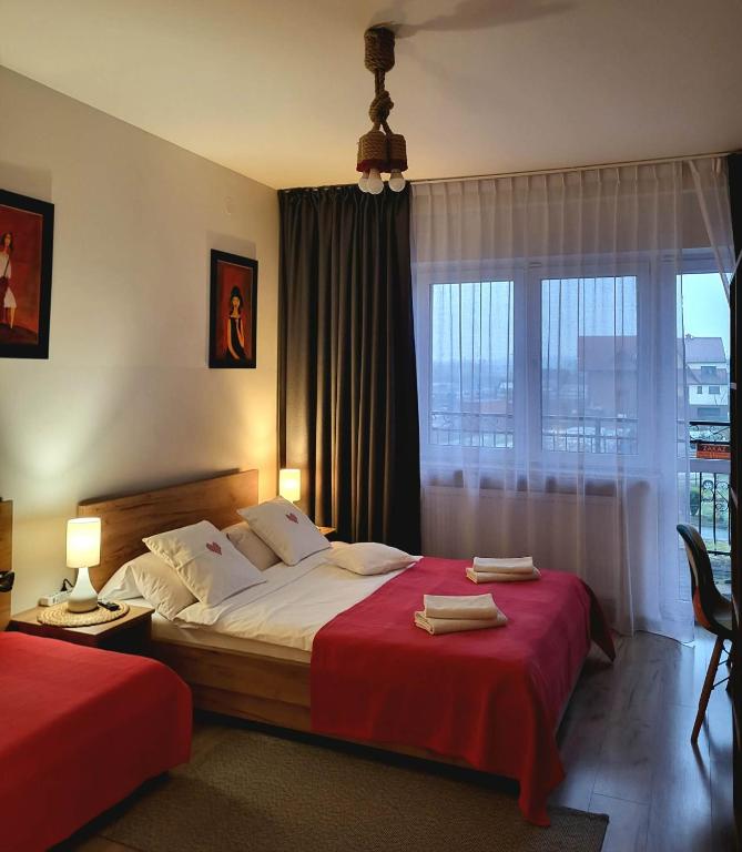 a bedroom with two beds and a large window at Pokoje Gościnne U Anny in Nowy Targ