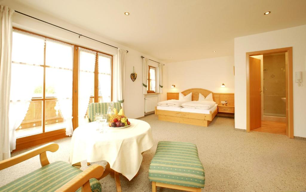 a hotel room with a bed and a table and chairs at Gästehaus Bernhard in Krün