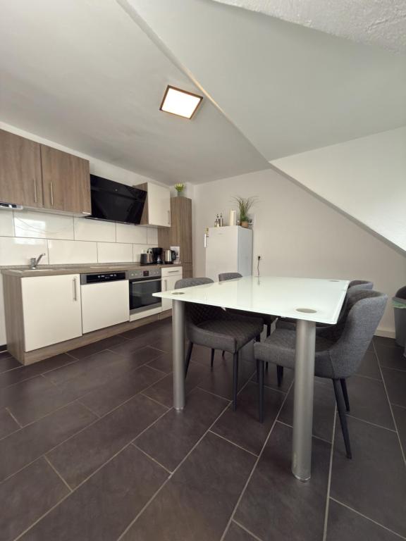 a kitchen with a white table and some chairs at Schönes Zimmer im Zentrum - 2 in Paderborn