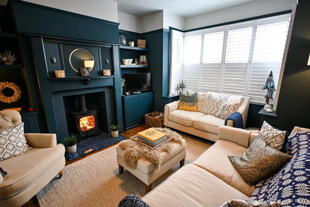 a living room with two couches and a fireplace at Hythe House in Hythe
