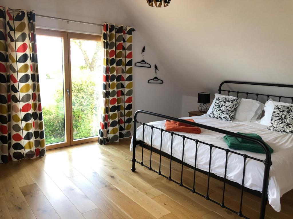 a bedroom with a bed and a large window at Larks Rise in Bruisyard