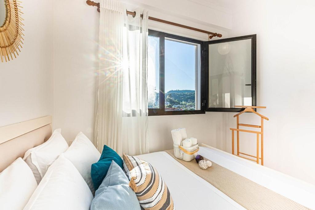 a living room with a white couch and a window at Shiny 2 Central Stay in Himare