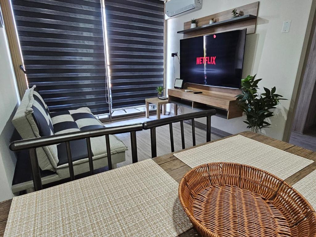 a living room with a tv and a couch and chairs at Apartamento Los Andes II in Los Andes