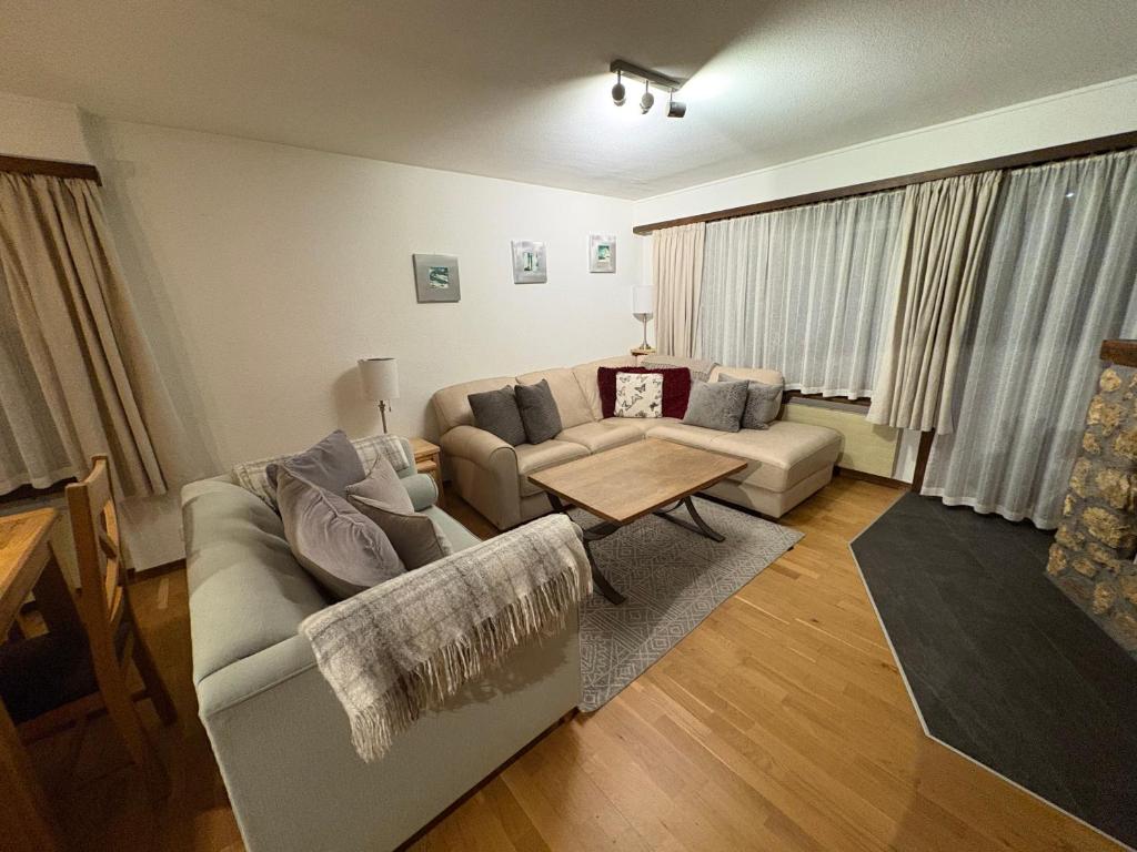 a living room with a couch and a table at Modern Täsch Apartment with Free Parking in Täsch