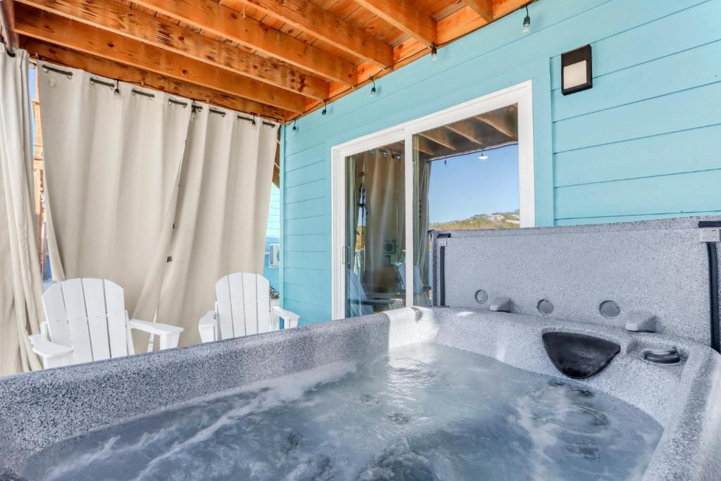 a jacuzzi tub in a blue house with chairs at The Container Retreat - 7A.. in Canyon Lake