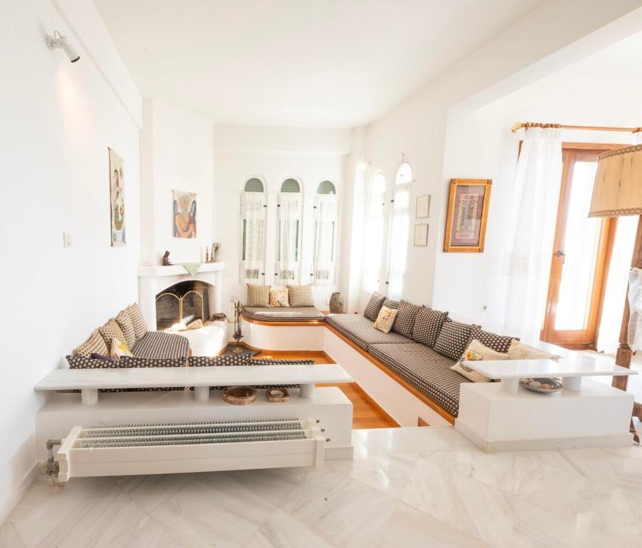 a living room with a couch and a fireplace at Dual bay views by ΜΡS in Dhaskalión
