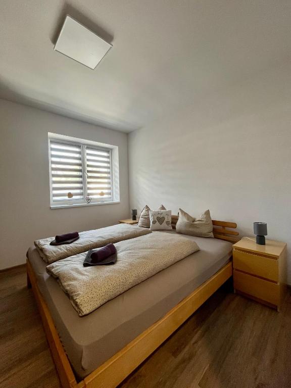 a bedroom with a large bed and a window at Apartmány Tobias in Běšiny