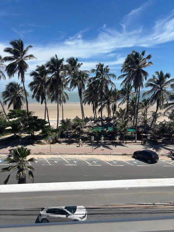 a white car driving down a road with palm trees at Litorânea Top View ' Beira Mar ' 15 Hospedes in São Luís